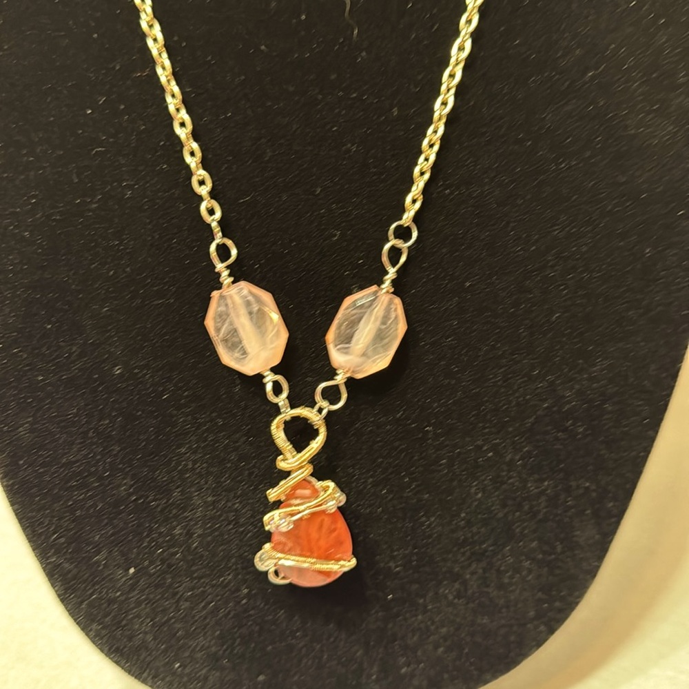 Handmade wrapped necklace with a pink wrapped bead.